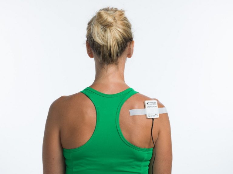 Woman standing with a FlexPulse PEMF coil pad on her shoulder