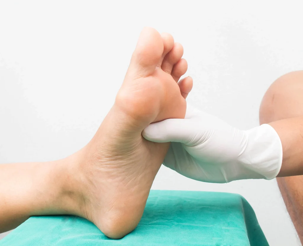 Doctor applies pressure to the soles of a patient's foot