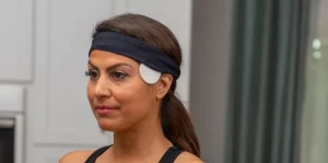 Athletic woman using PEMF machine coils wrapped around her head