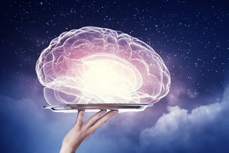 Outline of a brain being held up on a silver platter by a hand with stars and clouds in the background