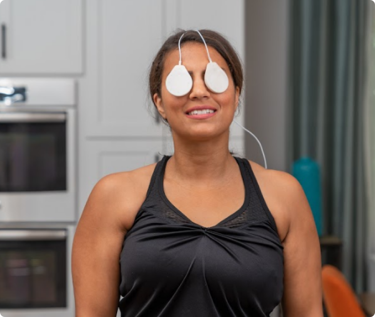 Coil pads resting over a woman’s closed eyes