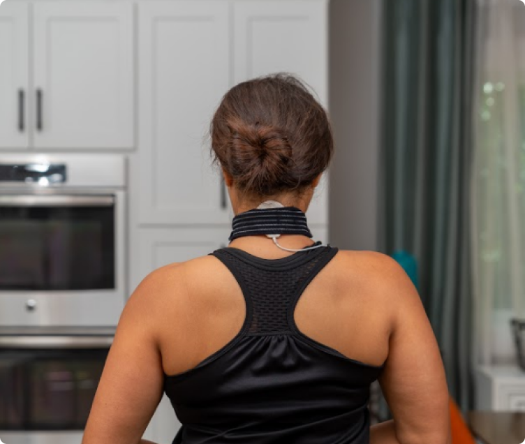 Coil pad strapped to the back of a woman’s neck