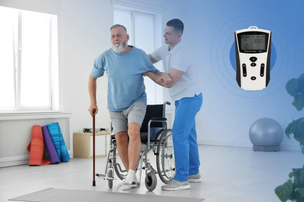 Young man helping older man out of wheelchair to walk, and a FlexPulse G2 device nearby (Picture 1)